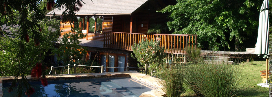 A view over the pool onto the Lemon Tree Self-Catering Cottage at Zauberberg